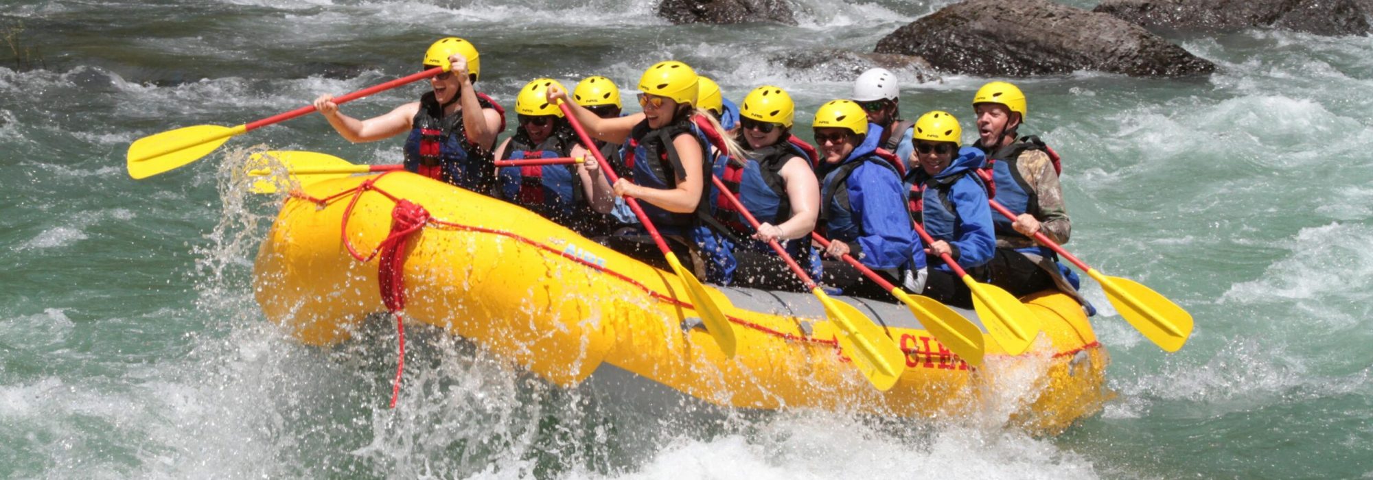 Exciting whitewater rafting team navigating rapids, showcasing teamwork and adrenaline-filled action.
